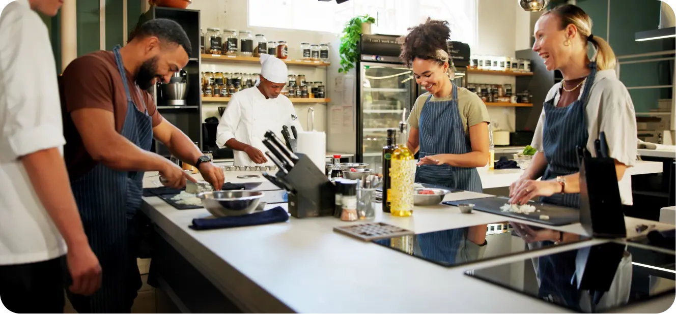 Equipo de trabajo cocinando pasta en una integración empresarial en Bogotá